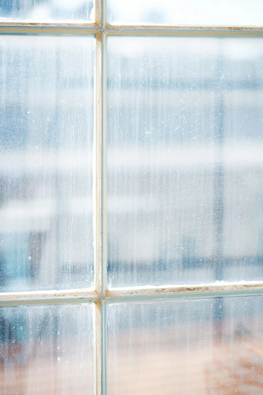 the corner of a window with white, partially closed glass