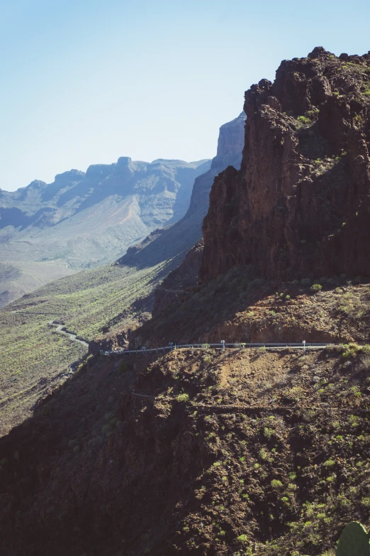 a train traveling through a mountainous countryside next to a mountain