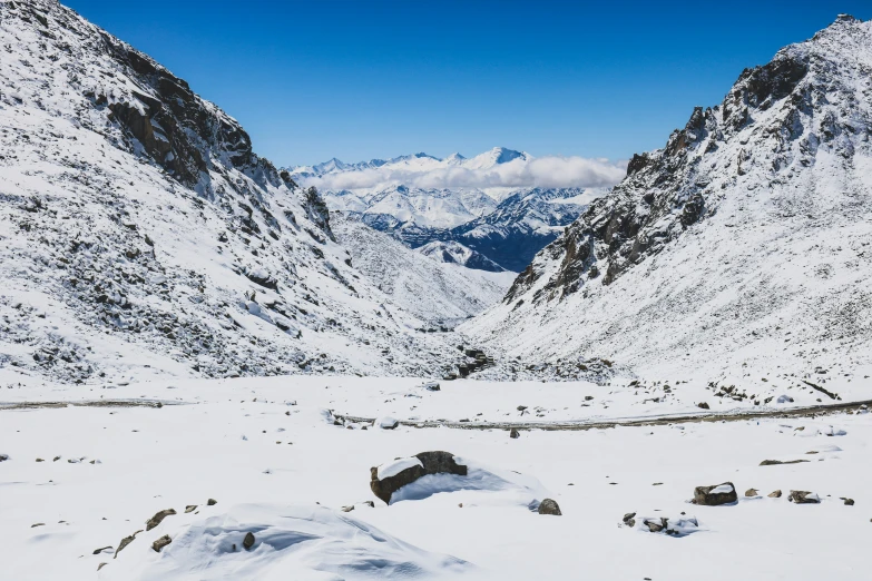 a snowy mountain with mountains and trees in the background