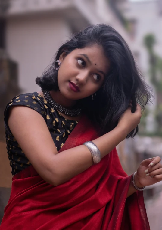 a young woman in red saree posing for the camera