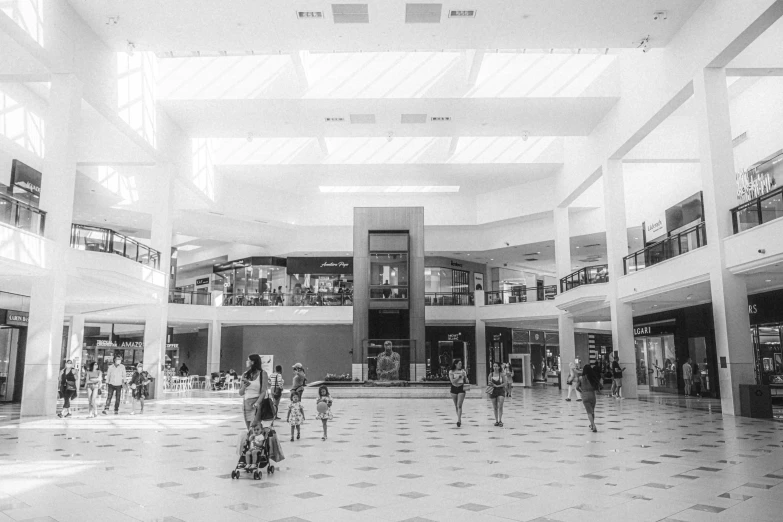 a large atrium with people walking and sitting on benches