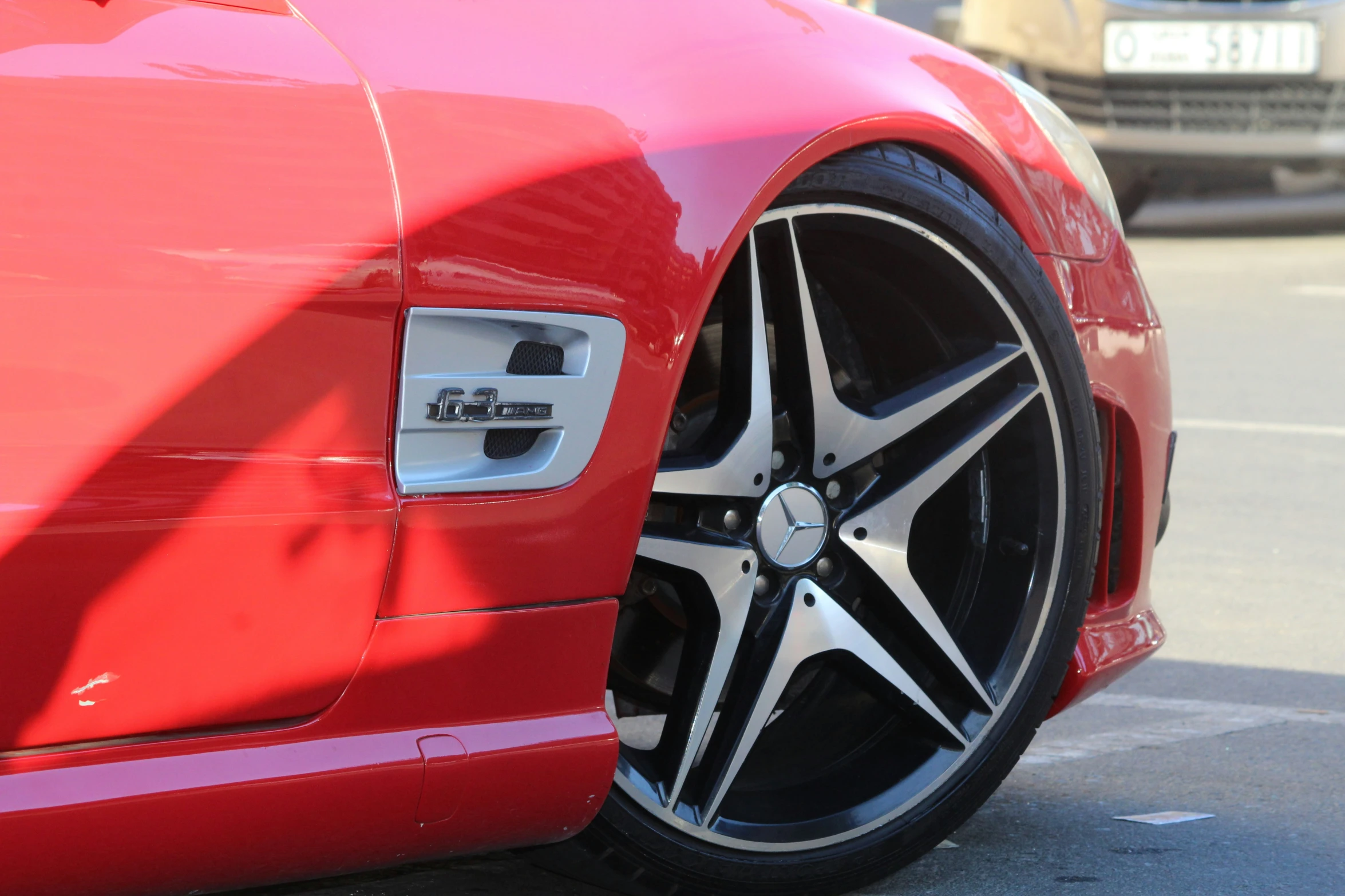 a red car sits parked in front of a silver car