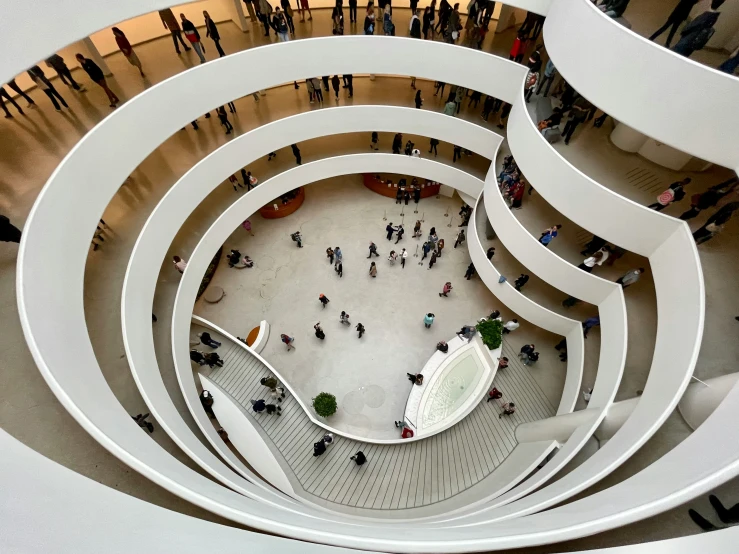 the view down into a crowd of people walking in a circular white spiral