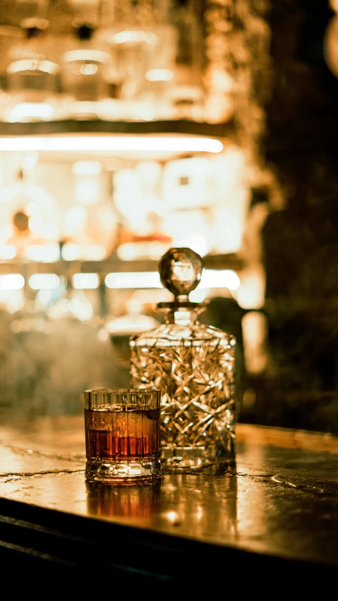 a glass bottle and crystal glass next to some liquor