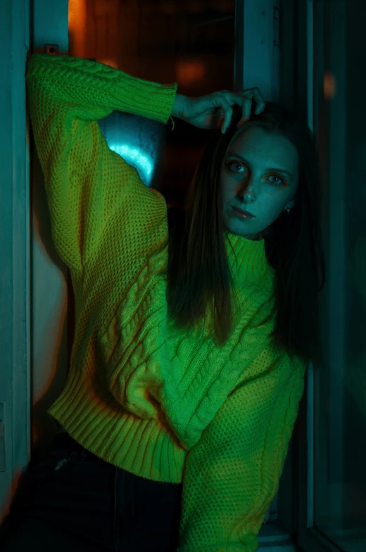 a woman wearing a green sweater with glowing light around her neck