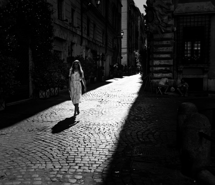 a black and white po of a woman walking down a city street