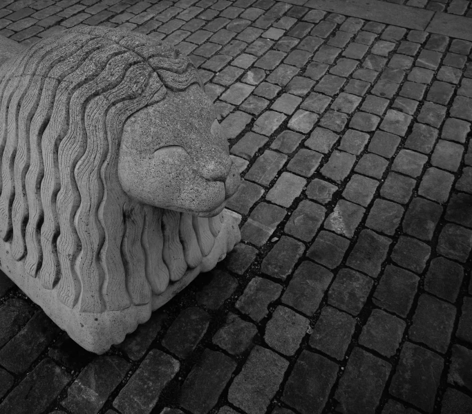 a stone lion is standing on a brick path