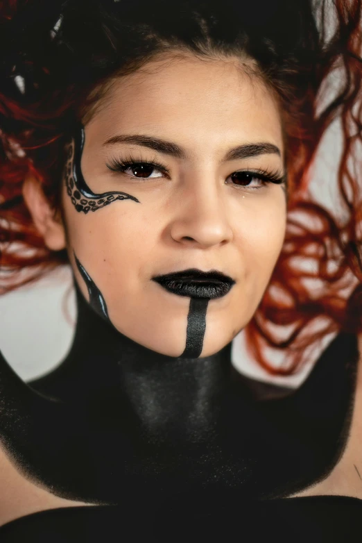 a woman with black makeup and black paint