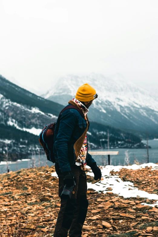 a person in winter clothing standing on the side of a mountain