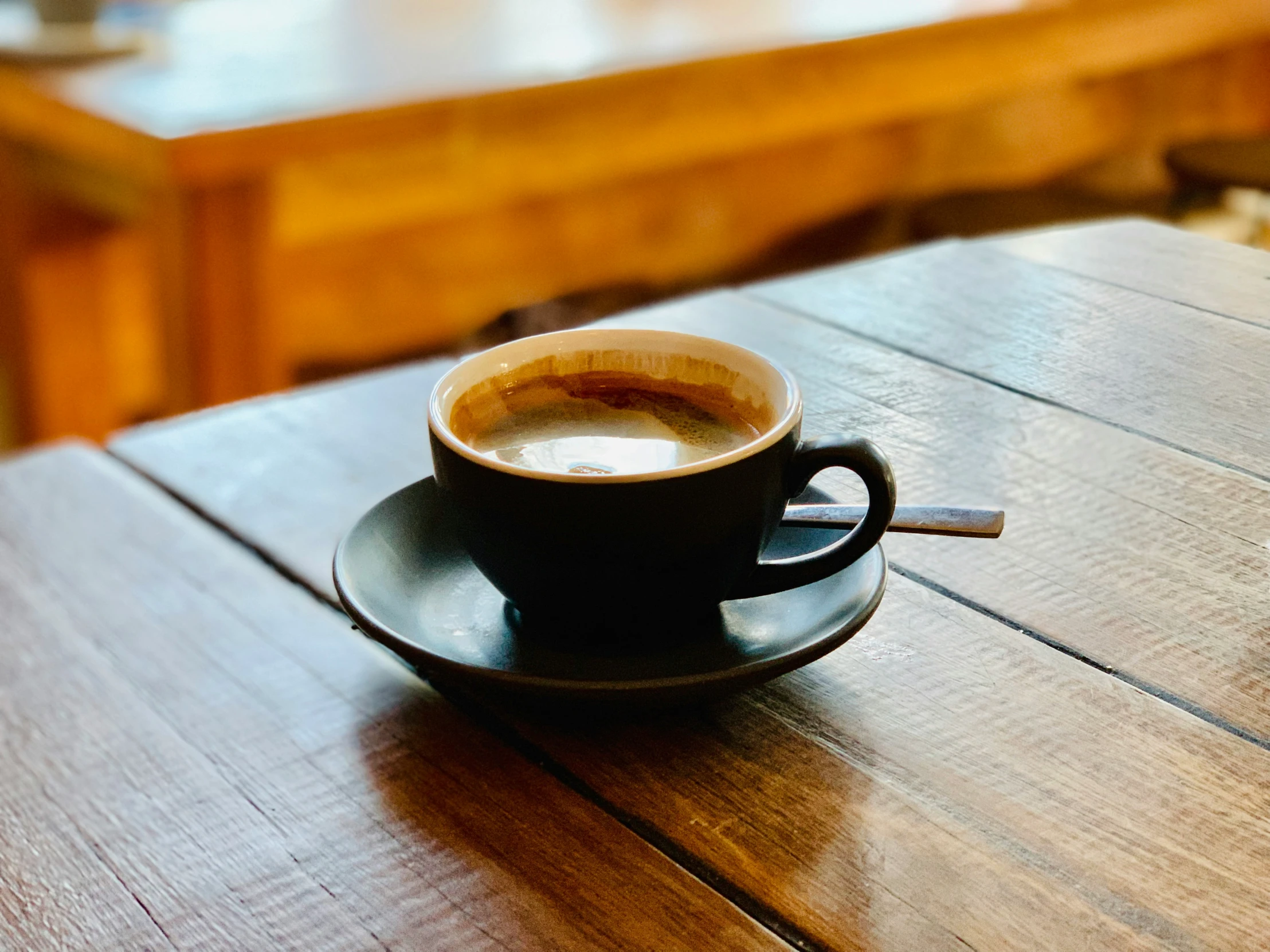 the wooden table has a cup on top