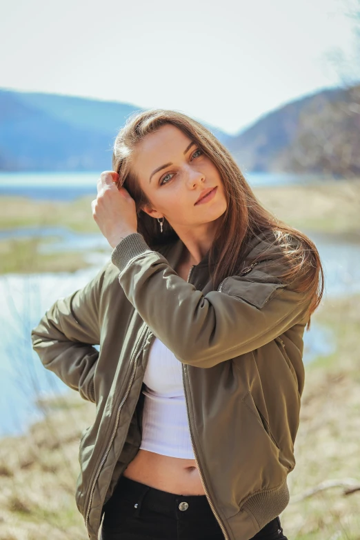 a woman standing outdoors in a green jacket