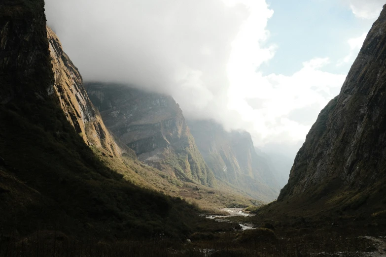 a narrow road next to mountains in a valley