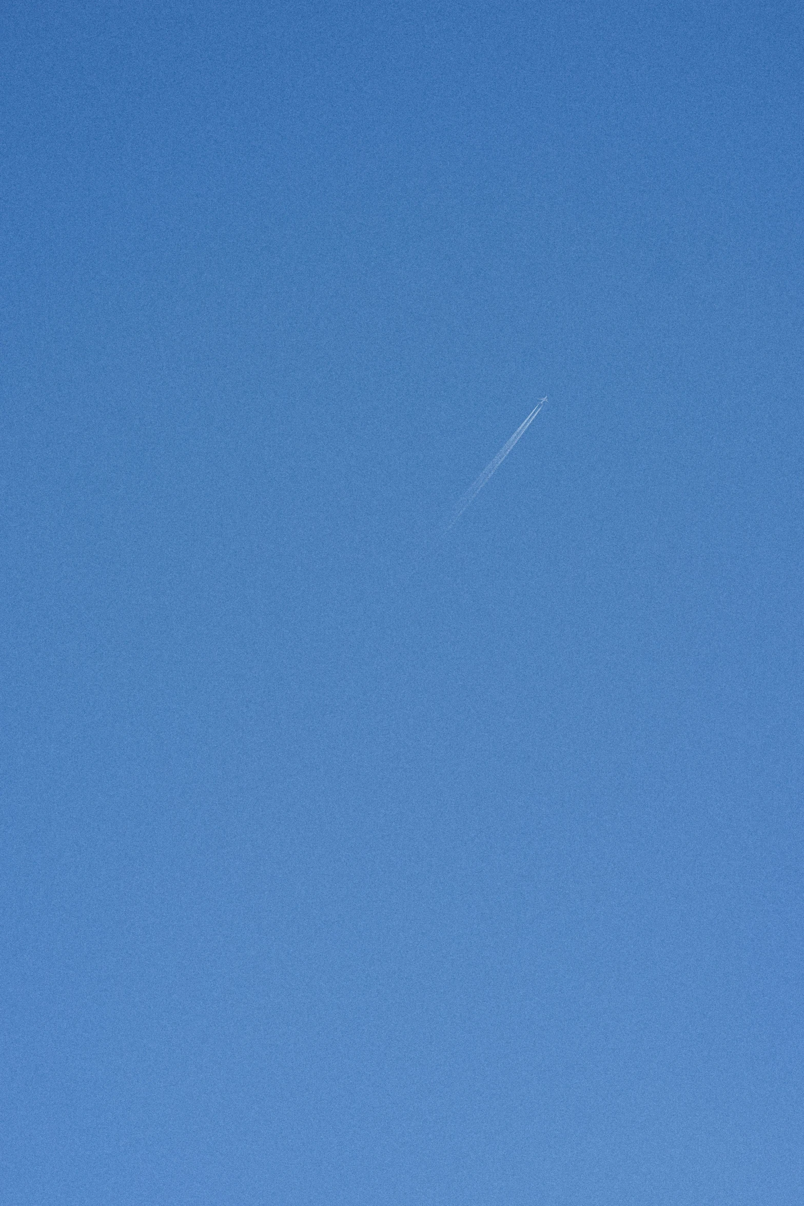 an airplane flies high in the blue sky