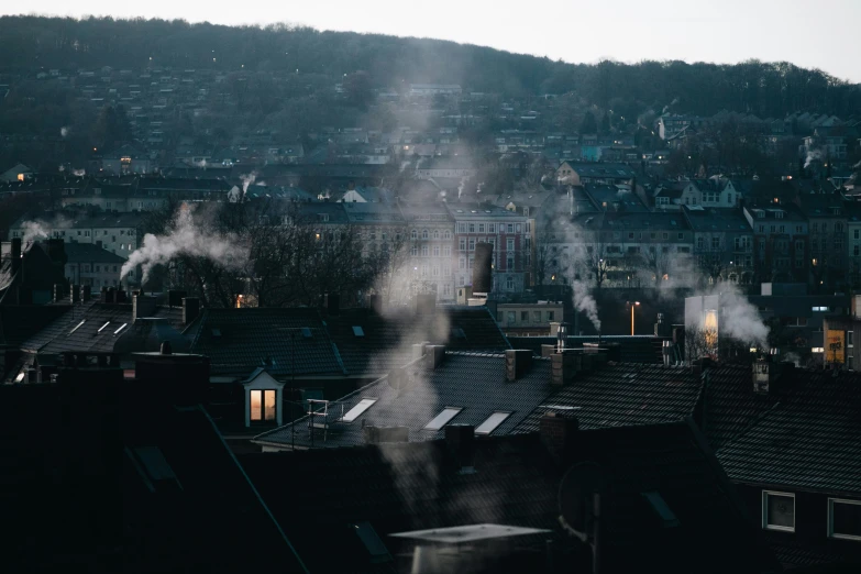 smoke billows from chimneys in a row of houses