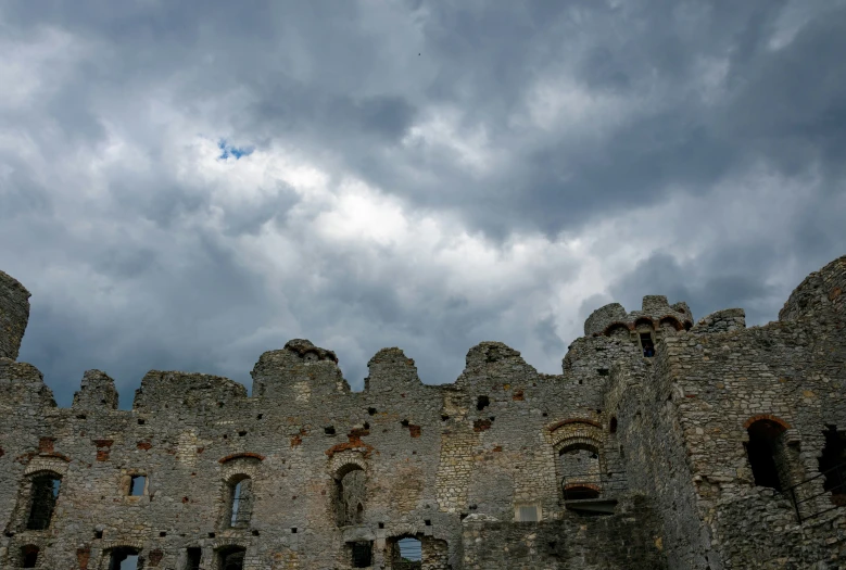 the clouds are gathering above the wall of this castle