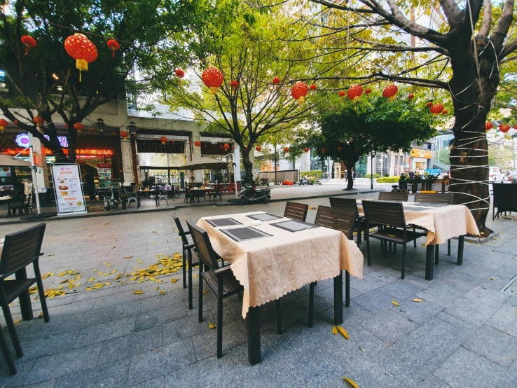 tables with cloth tablecloths set up in an open plaza area