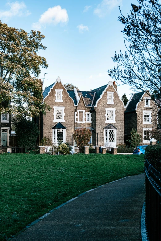 a building with trees, lawn and a walkway