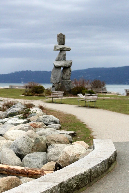 a bench sits by some rocks on a grassy field