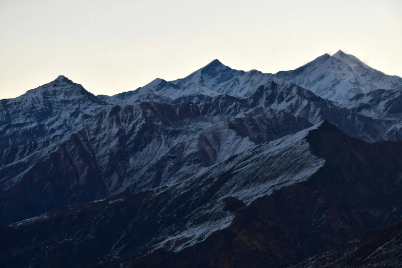 the snow capped mountains are covered with heavy coats of snow