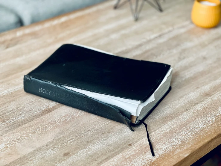 a large black binder is on the side of a small table