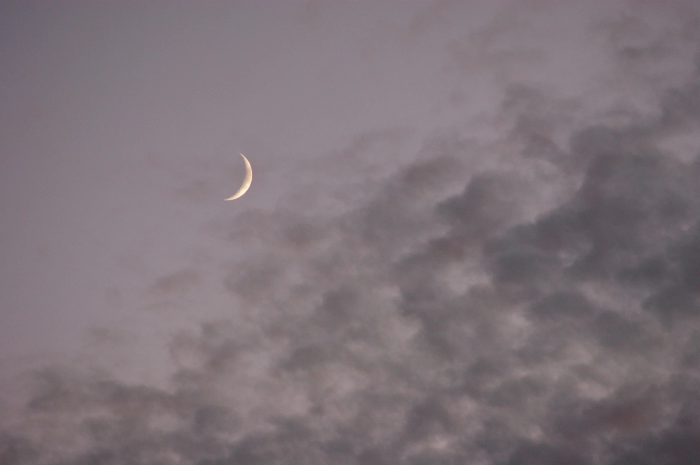 there is a half moon and clouds in the sky