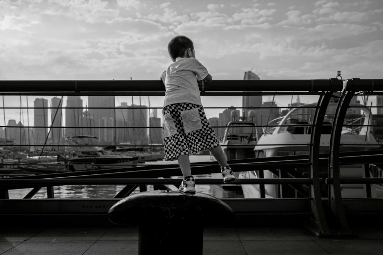 a girl stands on the railing overlooking a city