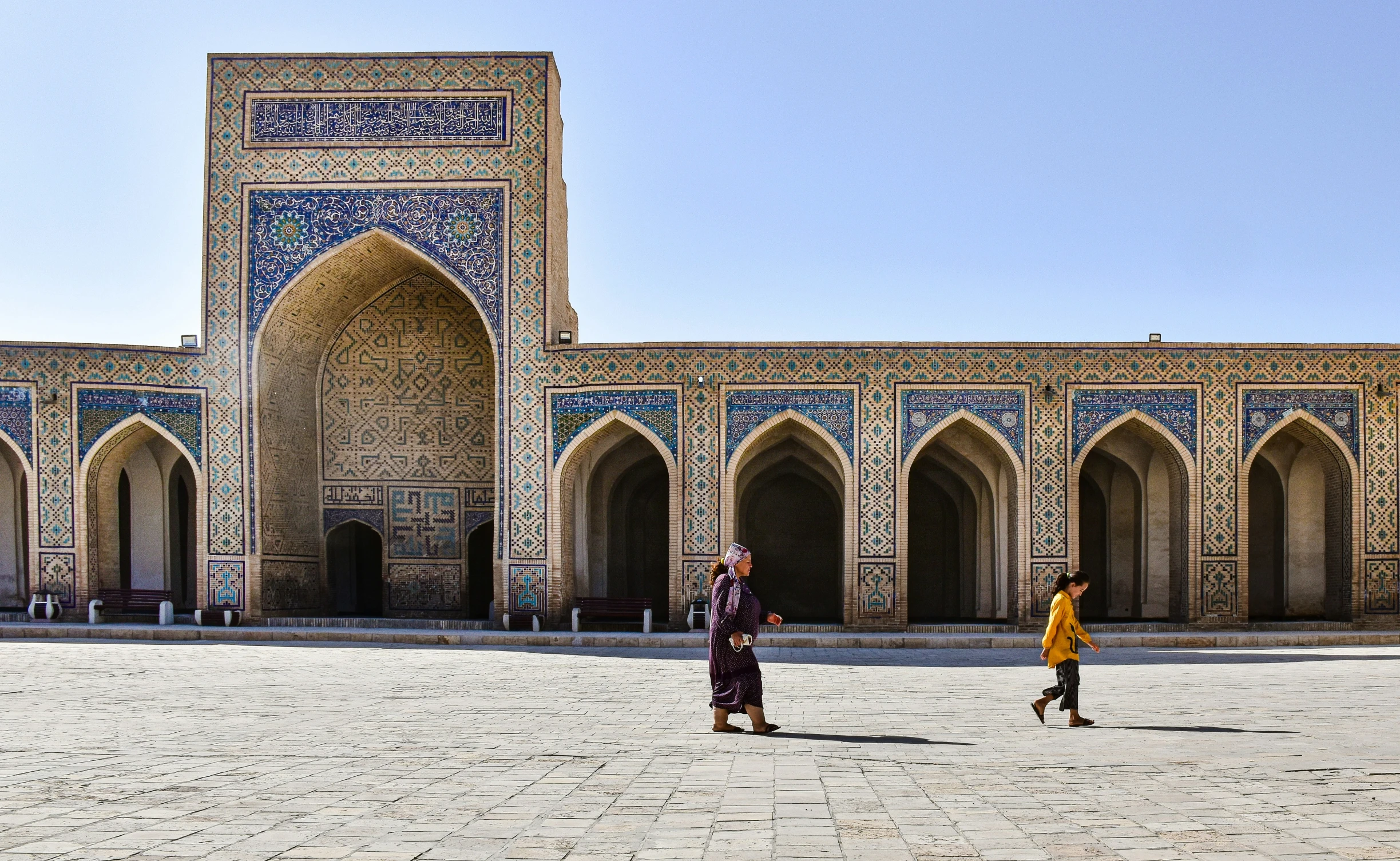 two men walking around in front of a large structure