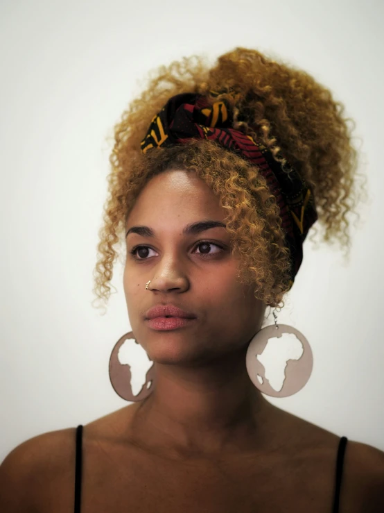 a close up of a person with blonde hair and big earrings