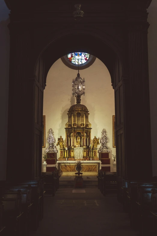 the altar in the church has candles, figurines and stain glass