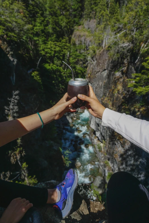 people standing at a steep, mountain side drinking a drink