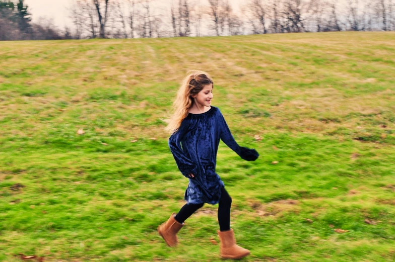 a child is running in a field holding a frisbee