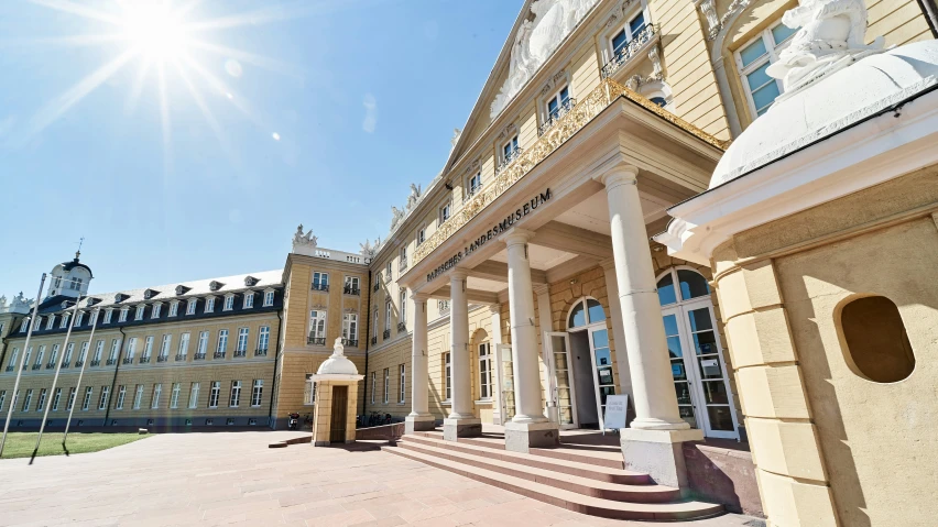 large building with many columns in front and a sun in the sky