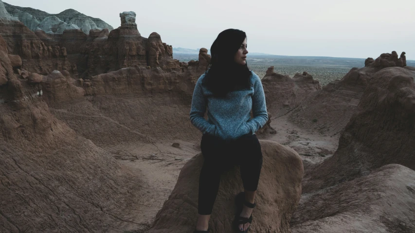 a woman standing on the rocks in the desert