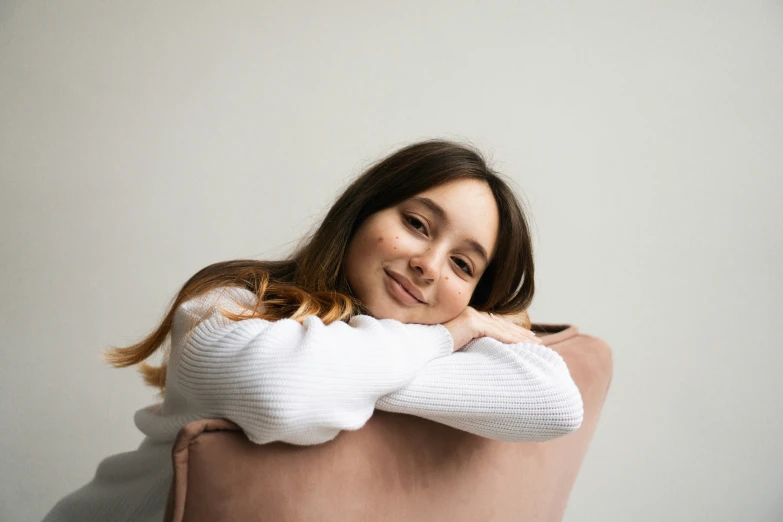 a woman with brown hair is hugging her pregnant belly