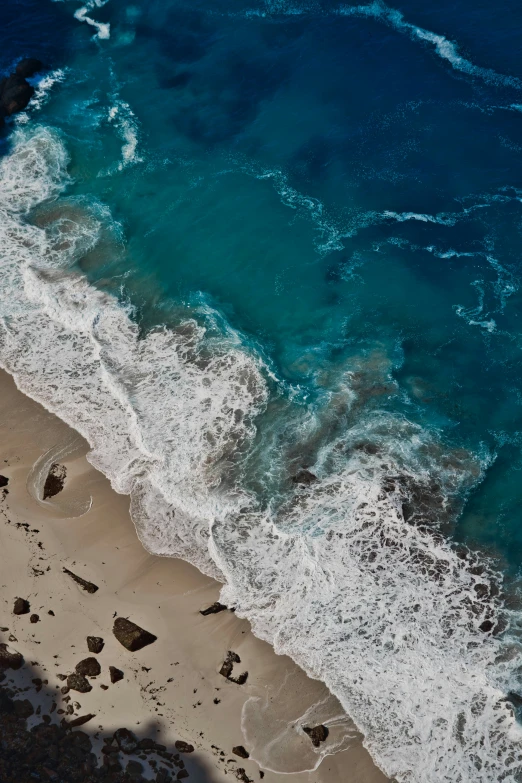 the water is blue and clear with white foam on it