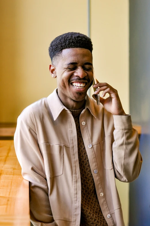 a man smiles while talking on a cell phone
