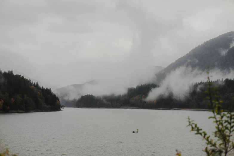 the boat is out in the water near the mountains