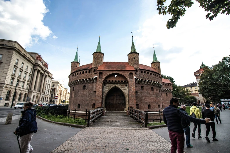 some people standing around and walking near an old brick building