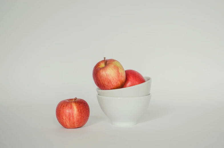 an apple sitting in a cup next to another apple