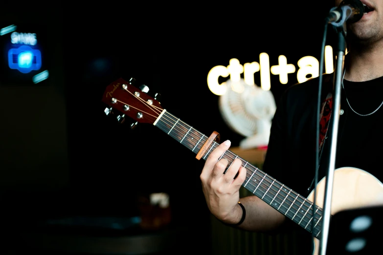 a man is playing the guitar while singing into a microphone