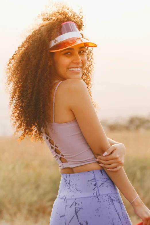 a beautiful young lady wearing a purple hat and sports 