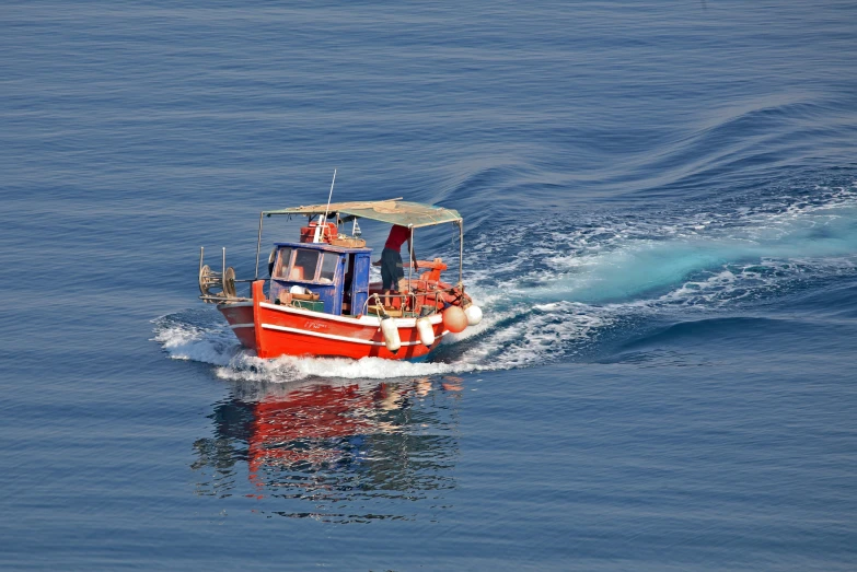 a red boat is going through the water