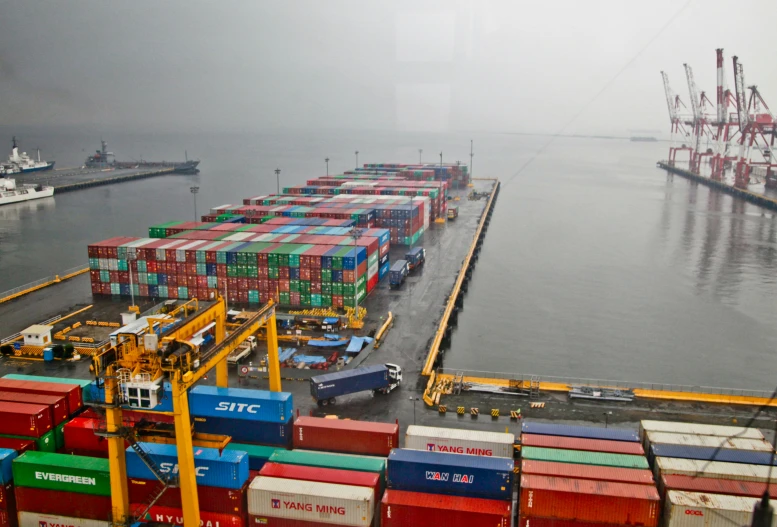 container ships at dock in ocean on a foggy day