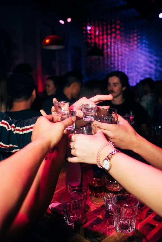 a group of people holding wine glasses over a table