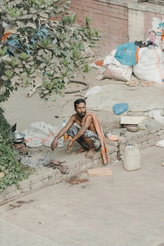 there is a boy sitting near a tree outside