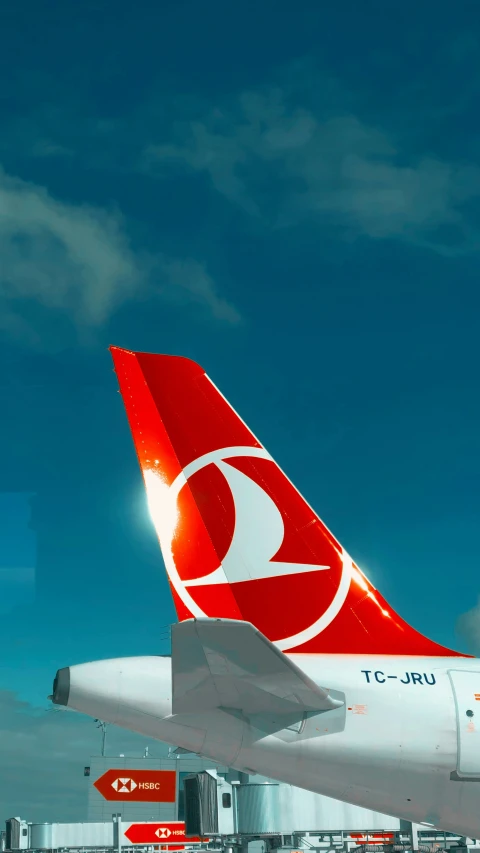 a red and white jet airliner sitting on top of an airport tarmac