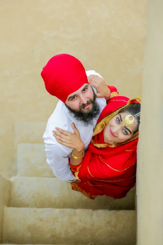 two people on the stairs, wearing clothes and a turban