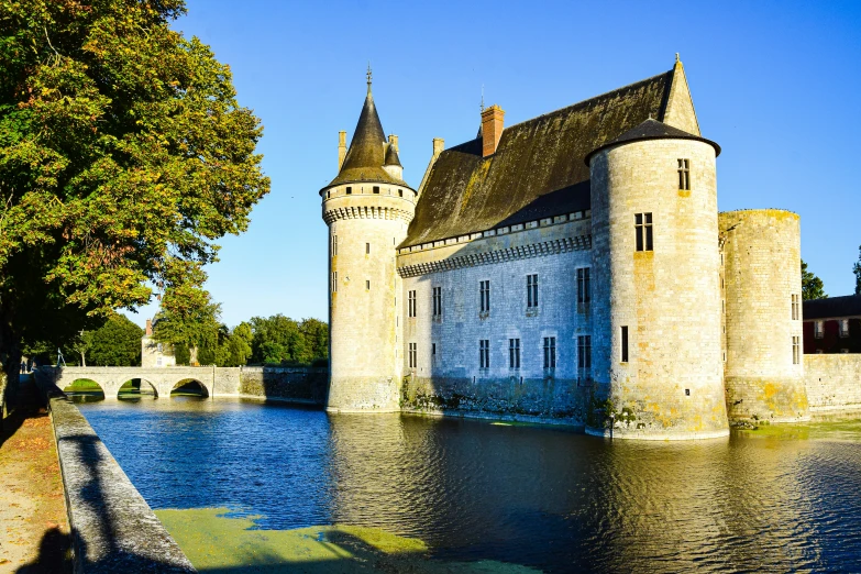 a castle with two towers next to a lake