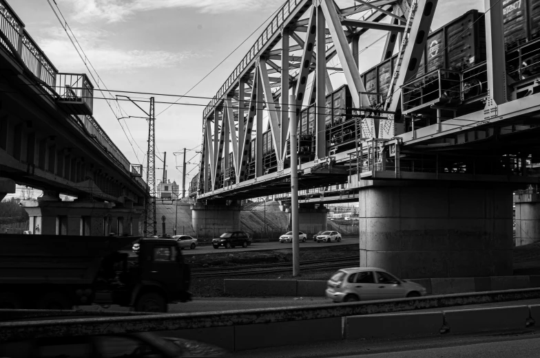 a black and white image of cars driving on a road