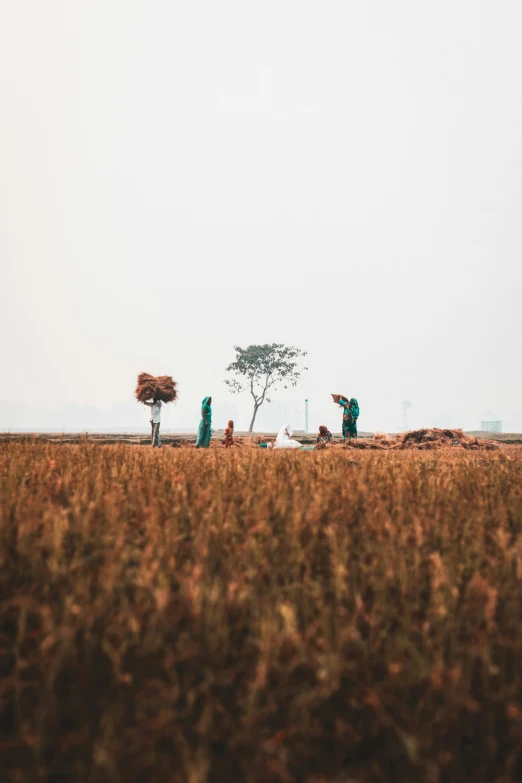 a group of people standing in the middle of an open field